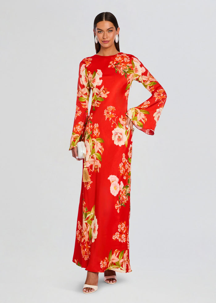 Full-length view of a model wearing a red floral maxi dress with bell sleeves and a white tassel clutch. media 3 of 5