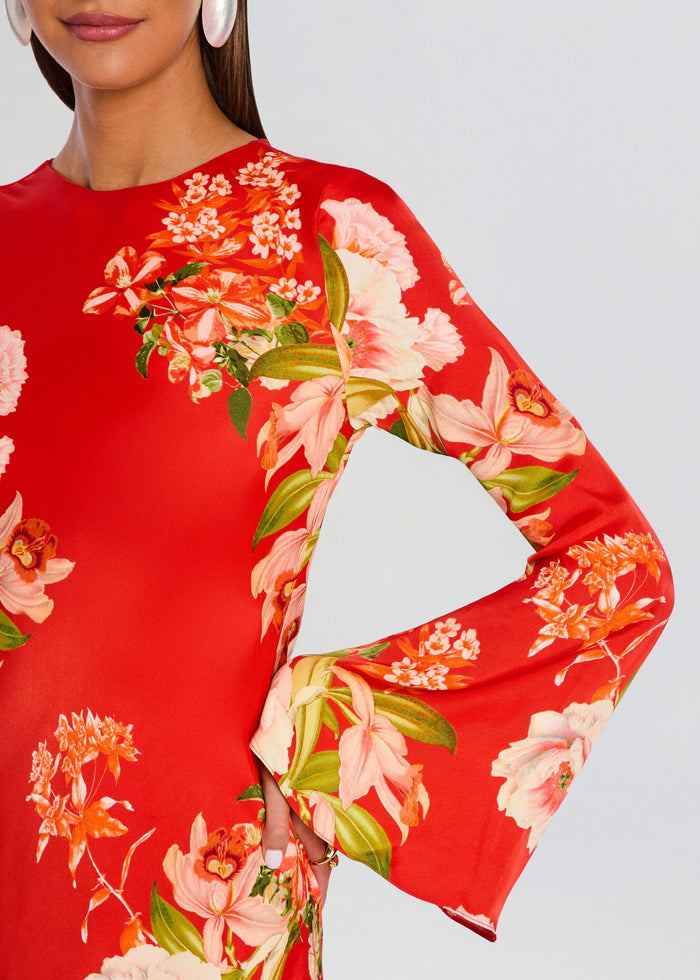 Close-up of the dress sleeve showing large pink flowers and green leaves against a red background. media 2 of 5
