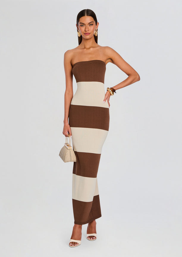 Full-length model wearing the Carrie Knit Maxi Dress in brown and cream color blocks with a small woven handbag.
