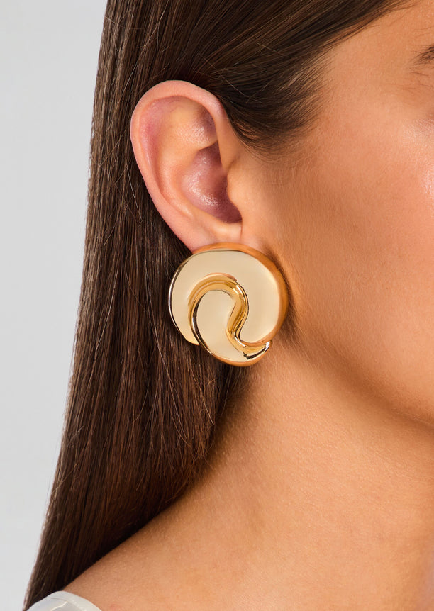 Gold Doma Earring worn on ear with a large circular disc and curling inner detail