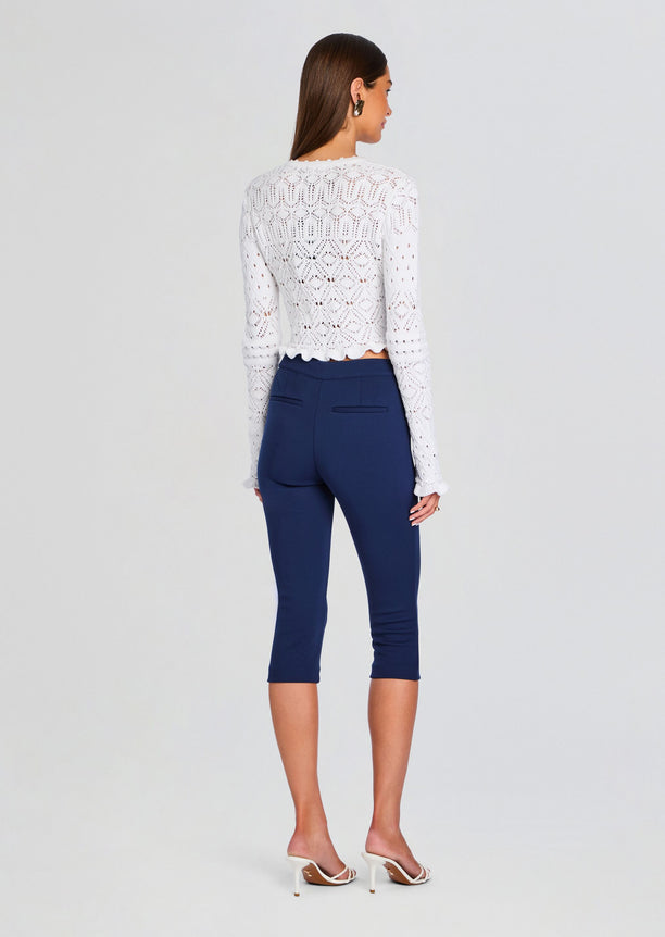 Back view of model wearing Giuliana Crochet Cardigan over navy cropped pants.