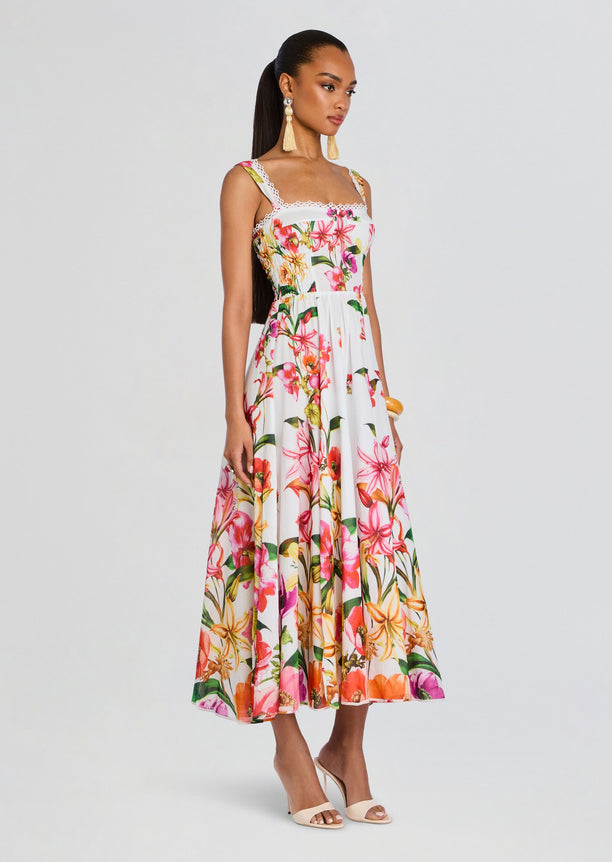 Model wearing Maui Long Dress, a white tropical floral print maxi with lace trim and wide straps.