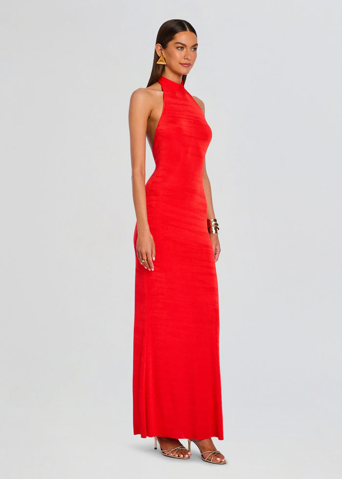 Full-length side view of a model wearing a red halter neck maxi dress media 3 of 5