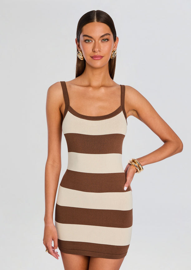 Front view of the model in a beige and brown striped knit mini dress with thin straps.
