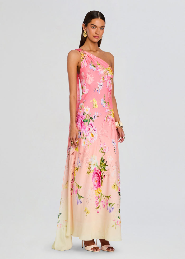 Full-length view of the pink floral Avya one-shoulder sash dress with a pale cream hem. media 3 of 5
