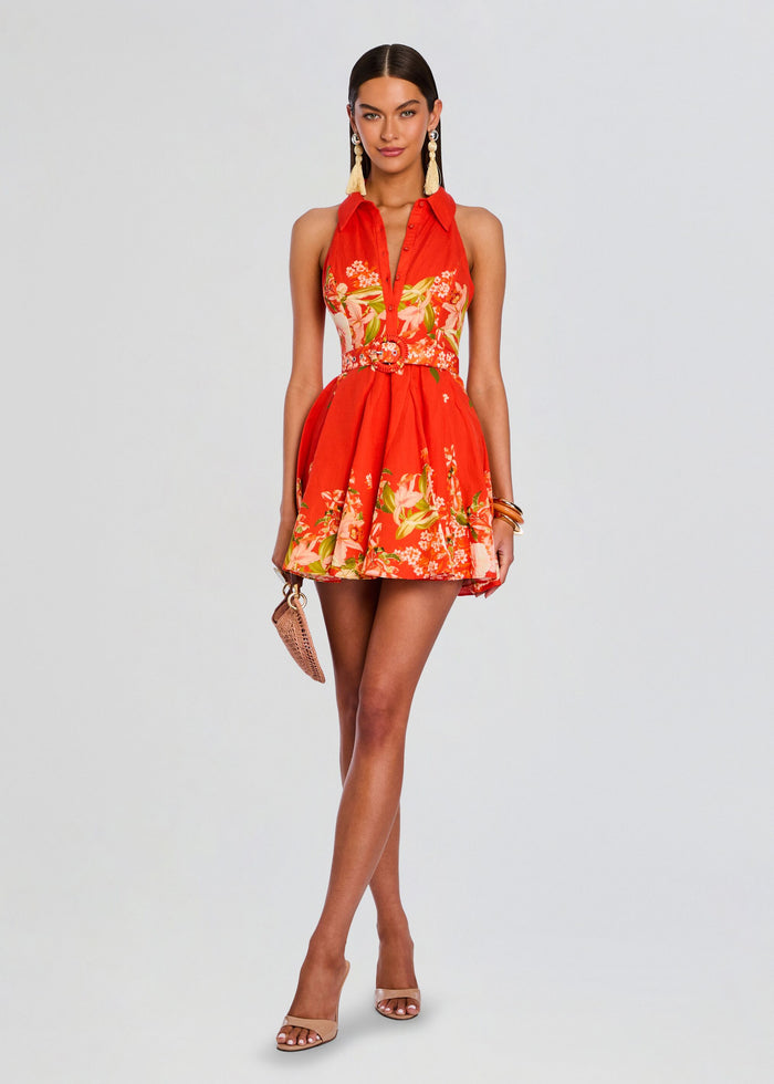 Model wearing Hibi Short Dress With Belt Buckle in red with floral print and a matching circular belt buckle. media 1 of 5