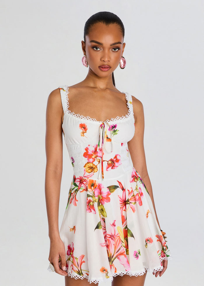 Front view of a model in Bora Short Dress white with vibrant floral print and lace-trim straps media 5 of 5