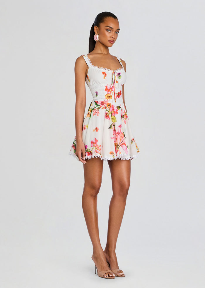 Full-length front view of model in Bora Short Dress with floral print lace trim and nude heels media 3 of 5