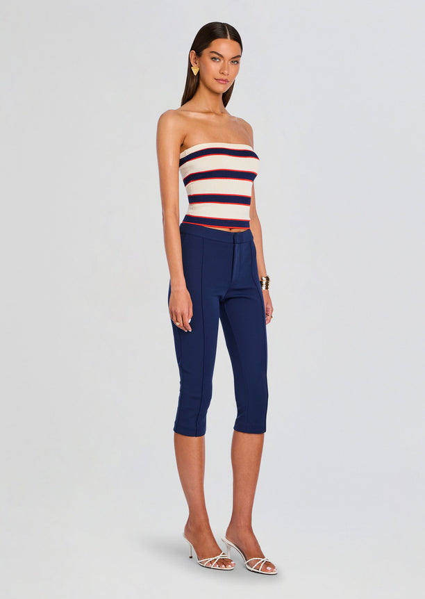 Model wearing Theodora Tube Top with cream base and navy and red stripes, paired with navy cropped pants.