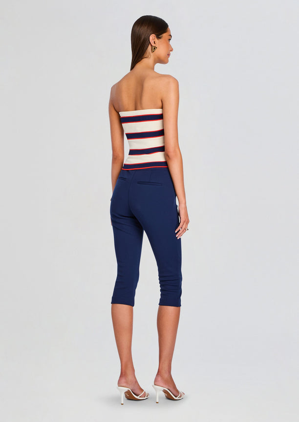 Back view of a model in Theodora Tube Top with cream and navy red stripes and navy cropped pants.