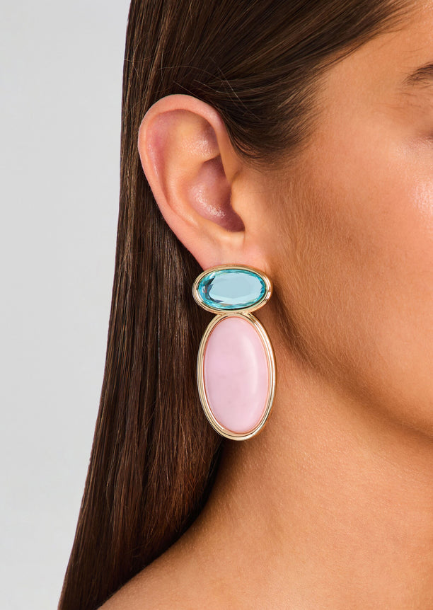 Yolanda Earring worn on ear with blue oval gemstone above a pink oval drop in a gold setting