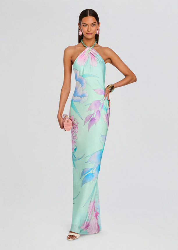 Model in a pastel floral Anat Dress halter neck maxi dress in mint with pink and purple blossoms