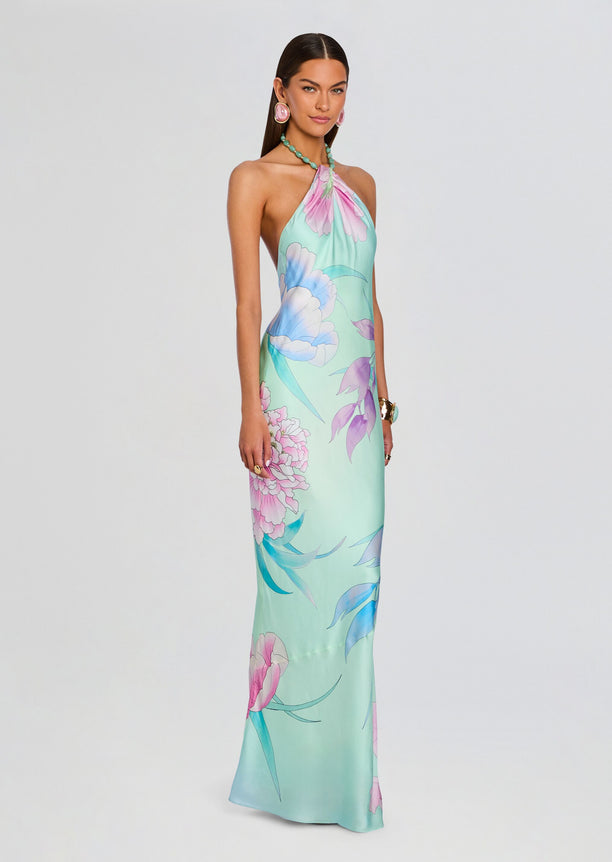 Full-length view of a model wearing the pastel floral Anat Dress with halter neckline