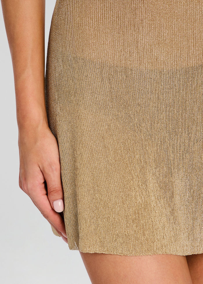 Close-up of a person wearing a beige skirt on a plain background media 2 of 5