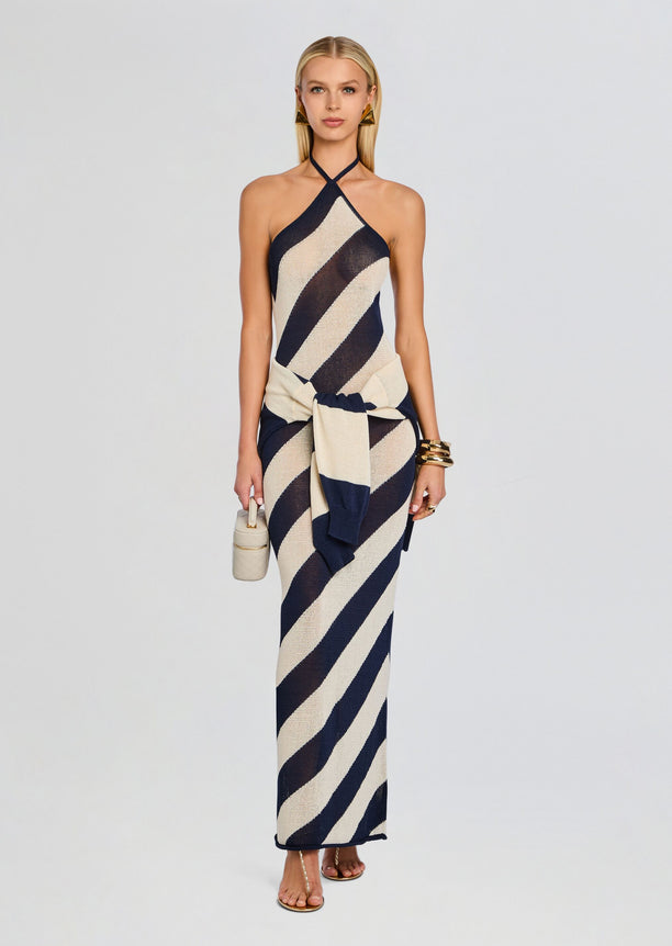 Full length shot of a model wearing a navy and beige diagonal stripe knit maxi dress with a front knot at the waist.