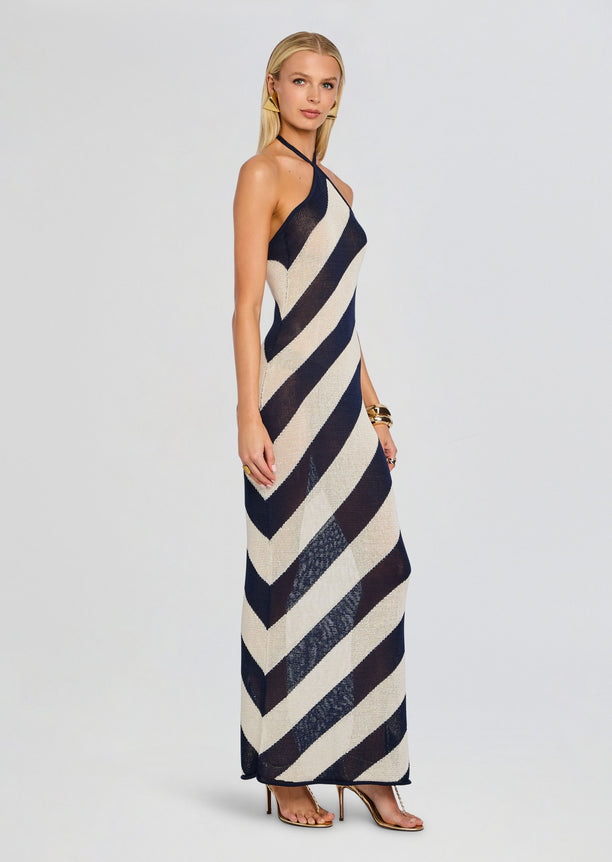 Side view of the model in the Dree Knit Maxi Dress with bold diagonal navy beige stripes running to the floor