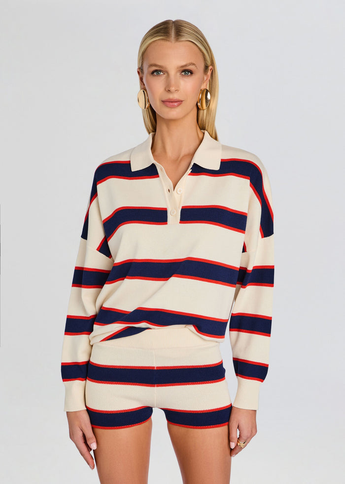 Front view of model in cream and navy red striped knit polo with matching striped shorts and gold hoop earrings. media 1 of 5