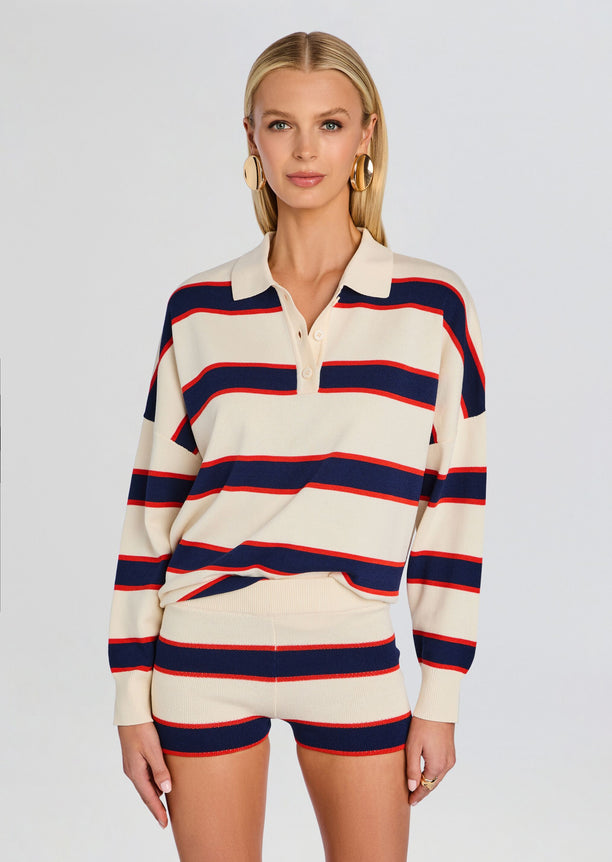 Front view of model in cream and navy red striped knit polo with matching striped shorts and gold hoop earrings.