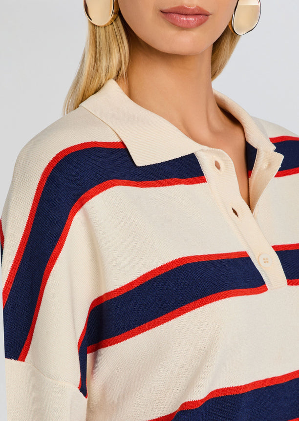 Close up of Taby Sweater showing cream knit with navy and red stripes and a polo collar.