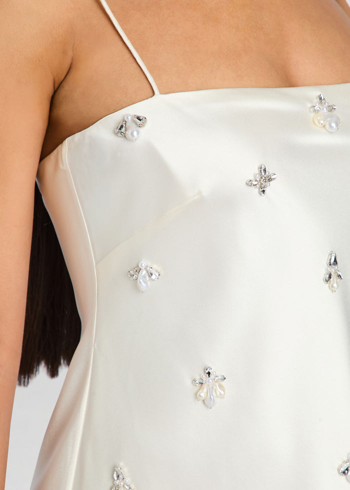 White satin dress with decorative embellishments on a plain background media 2 of 5