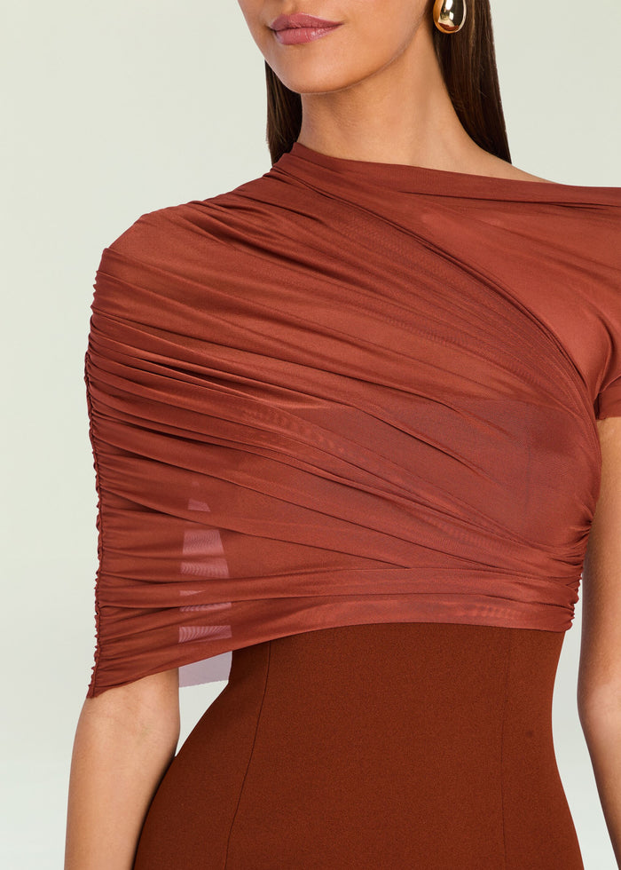 Close-up of a model wearing a rust-brown draped off-the-shoulder top with ruched detailing and a matching brown fitted bottom against a light neutral background. media 2 of 5