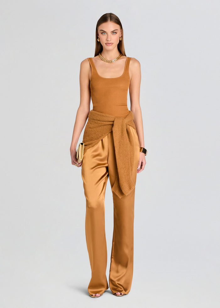 Woman wearing a mustard yellow sleeveless top and wide-leg pants on a light gray background media 2 of 5