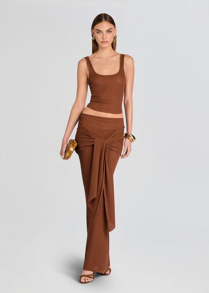 Woman wearing a brown outfit with a top and flowing pants on a light gray background media 2 of 5