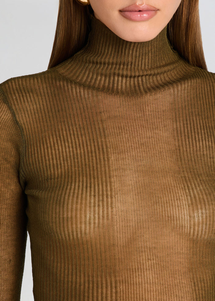 Close-up of a person wearing a brown ribbed turtleneck sweater. media 3 of 5