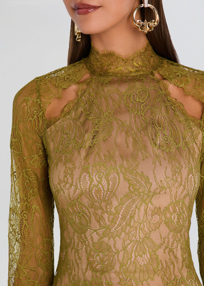 Close-up of a woman wearing a sheer olive green lace long-sleeve top with a high mock neck and cutout details at the shoulders. media 2 of 5