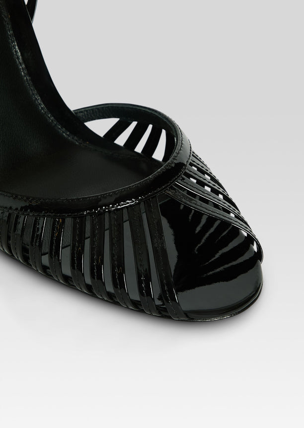 Close-up of black patent Analu Sandal front showing a sleek cage of thin straps
