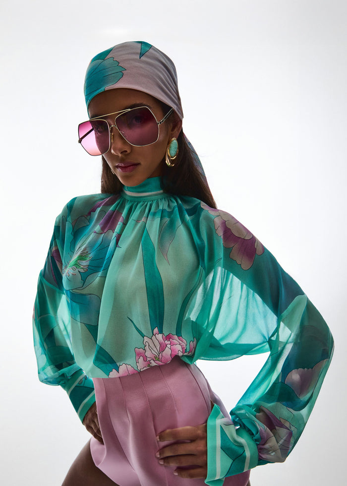 Model wearing Olympia Top in turquoise floral print paired with high-waisted pink shorts. media 2 of 7