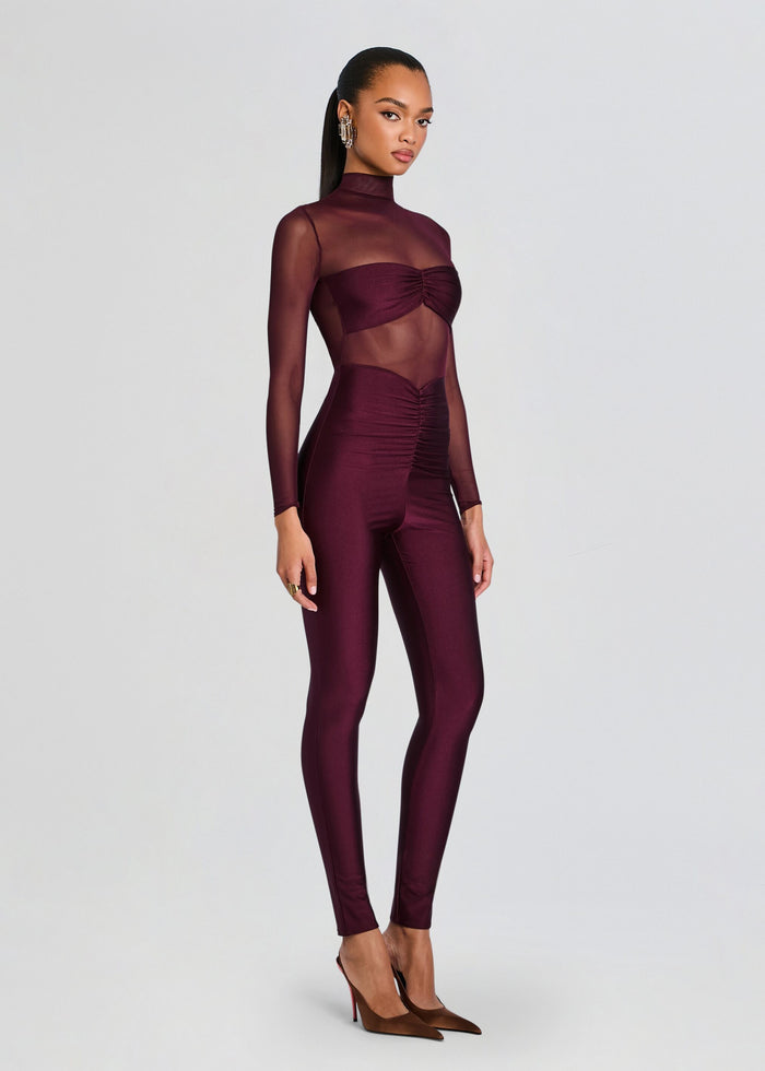 Full body profile of a model in burgundy Brietta Bandeau Mesh Catsuit with sheer sleeves and ruched waist. media 3 of 5