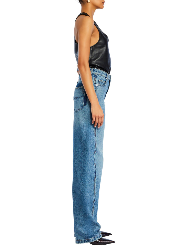 Side view of a model wearing a black faux leather tank top tucked into light wash wide leg jeans media 4 of 5