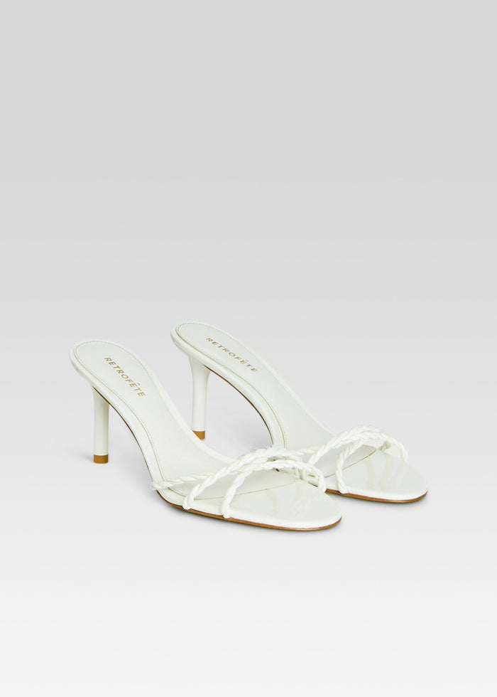 Pair of white Karolina Sandals with braided toe straps and kitten heels set on a light background media 4 of 5