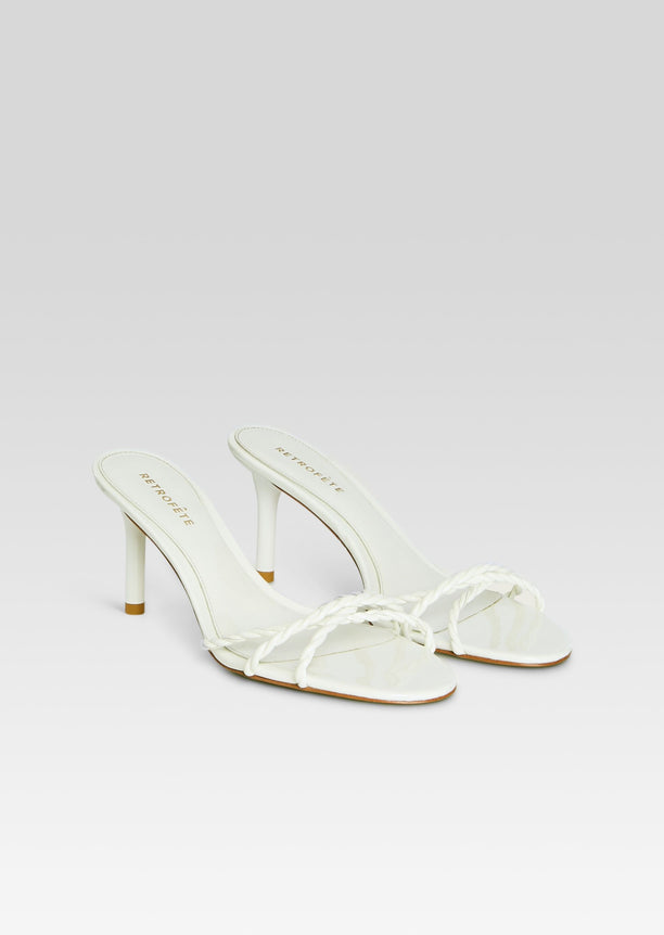 Pair of white Karolina Sandals with braided toe straps and kitten heels set on a light background