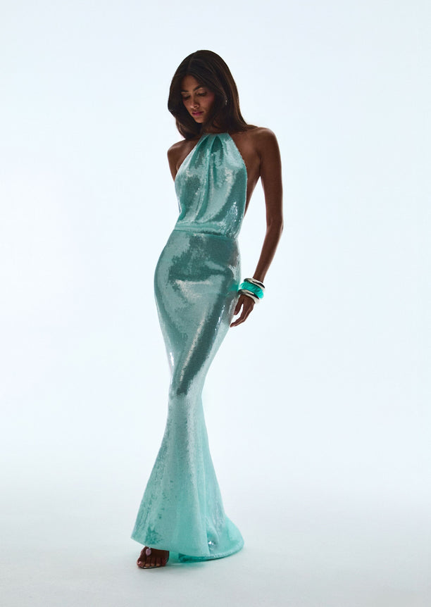 Model wearing Elexa Sequin Dress seafoam halter neck gown standing in studio.