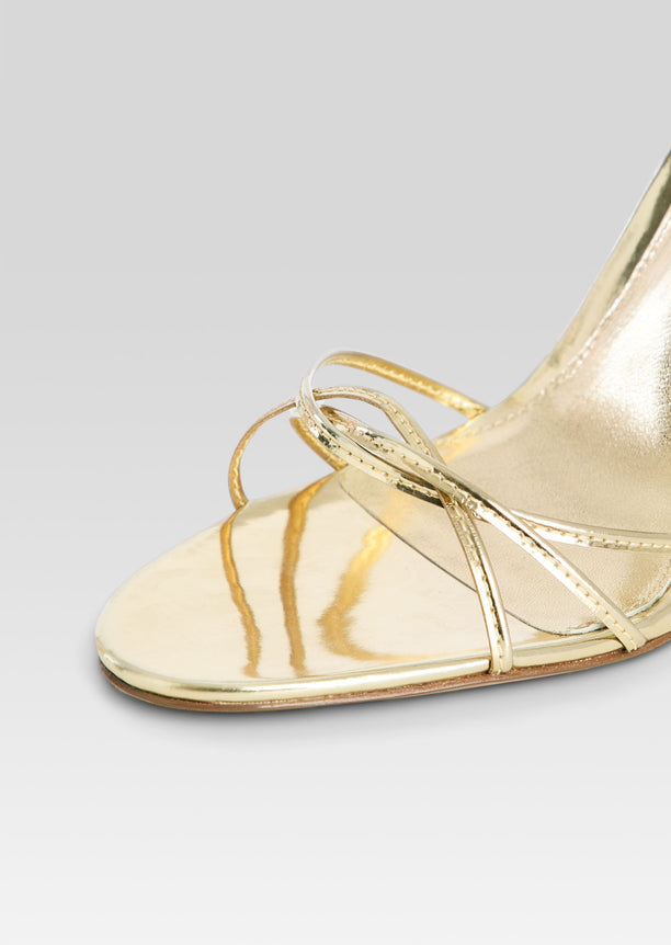 Close up of gold metallic Lucia Sandal front with thin crisscross straps over the toes