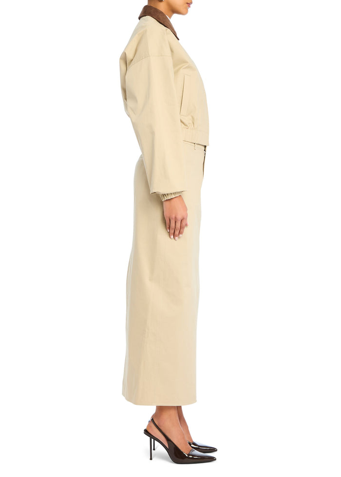 Side view of a model in the beige Marielle Jacket with a brown collar and matching belted wide-leg pants. media 3 of 5