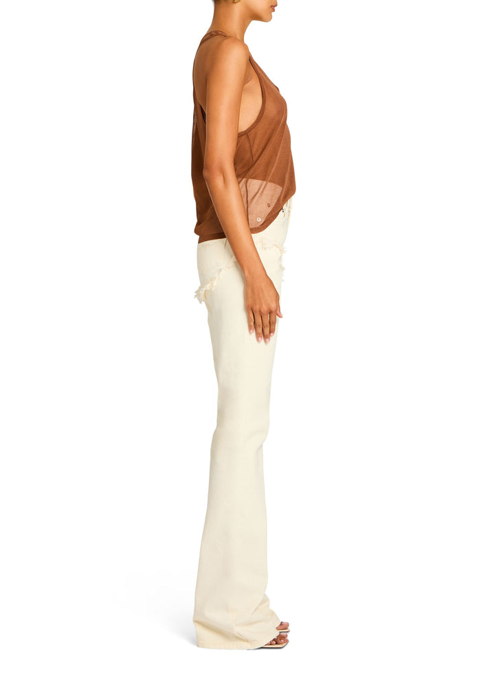 Side view of a model wearing a rust Arianna Knit Top with cream wide-leg pants. media 3 of 5