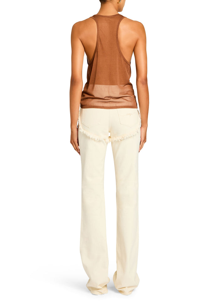 Back view of a model wearing a rust Arianna Knit Top with cream jeans featuring fringe at the back. media 4 of 5