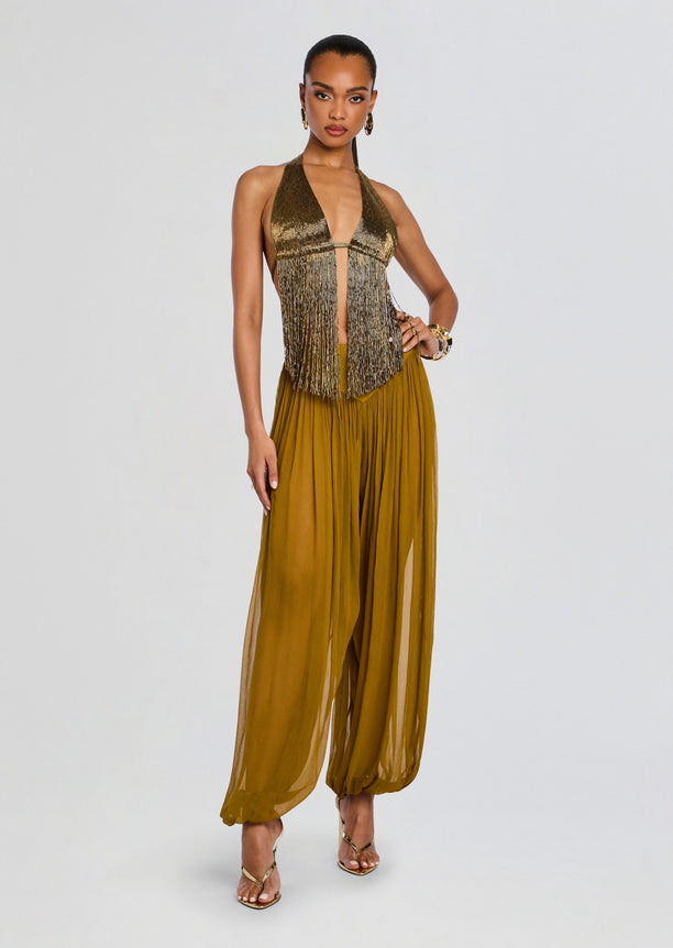 Model wearing the Marisel Pant set with a metallic fringe halter top and mustard flowy wide-leg pants.