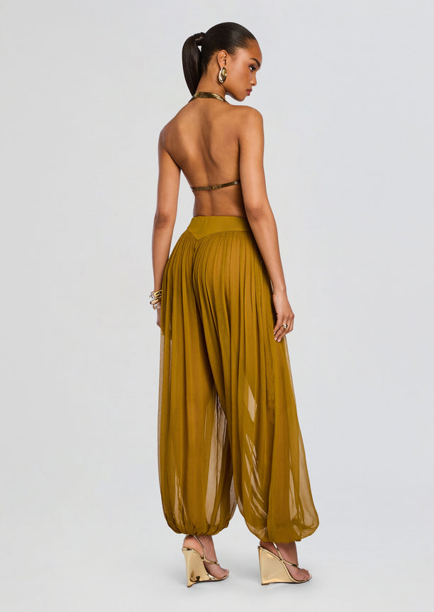 Back view of a model in Sereya Embellished Top with back strap and mustard wide-leg pants.