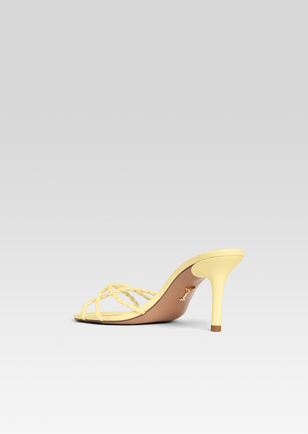 Karolina Sandal side view in pale yellow with braided front straps and a slender stiletto heel