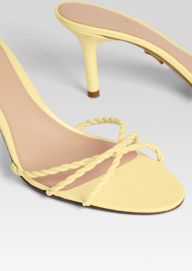 Close up of Karolina Sandal with braided pale yellow straps and open toe.