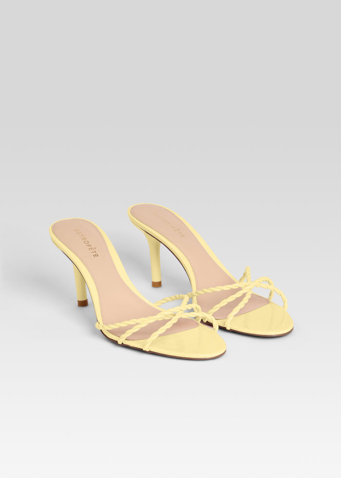 Pair of pale yellow braided strap Karolina Sandals on a light gradient background media 4 of 5