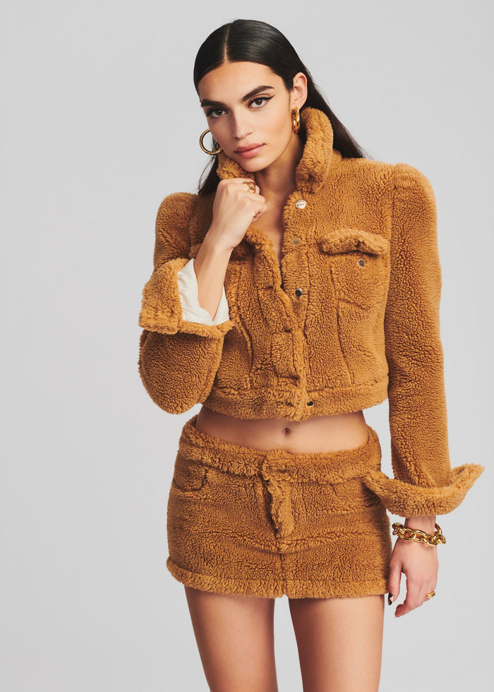 Model wearing a fuzzy caramel teddy jacket with pocket details and matching shorts. media 1 of 5