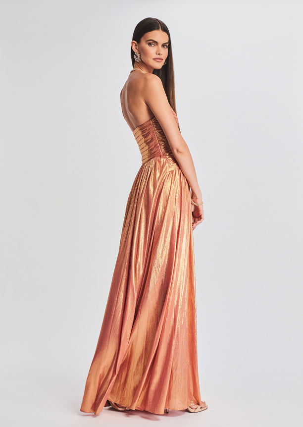 Side view of Waldorf Dress in metallic rose gold showing a cinched waist and flowing skirt with a high slit.