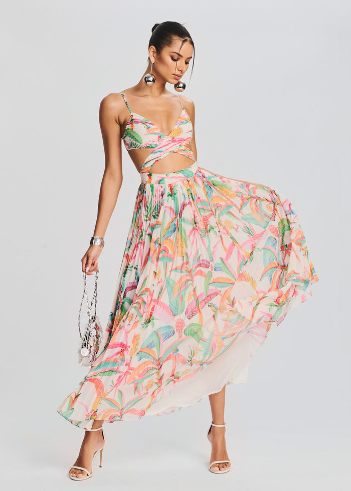 Model in a pink tropical print maxi dress with a cutout at the waist and flowing skirt media 5 of 5